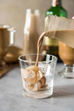 coffee being poured into a glass on top of a table