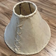 a white lamp shade sitting on top of a wooden floor