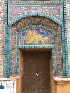 an ornate doorway with a lion painted on it