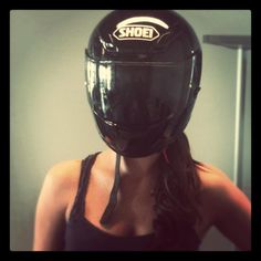 a woman wearing a helmet with the words shoei on it's face, in front of a mirror