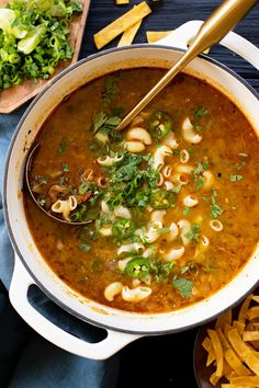 a bowl of soup with pasta and parsley on the side