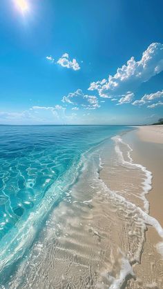 the beach is clear and blue with waves coming in from the ocean to the shore