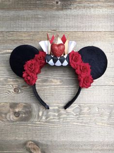 a mickey mouse ears headband with red roses on it and a crown in the middle