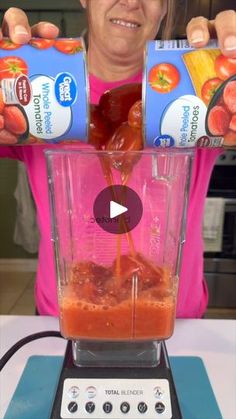 a woman pouring juice into a blender with tomatoes and oranges in it on the counter