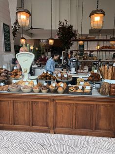 a counter filled with lots of different types of breads and pastries on it