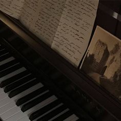 an old piano with writing on it next to a sheet of paper that has been placed on top of it