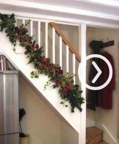 the stairs are decorated with holly garland and red berries for christmas decorations, along with other holiday decor