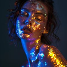 a woman with glitter on her face and body is shown in blue, yellow and orange