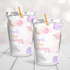 two cups with straws in them on a table