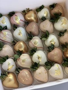 a box filled with chocolate covered strawberries and topped with gold leafy toppings