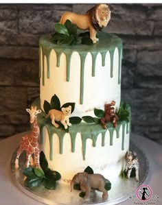 a three tiered cake decorated with jungle animals