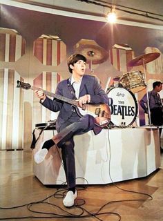 a man sitting on top of a table with a guitar