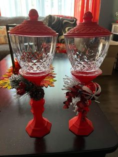 two red glass vases sitting on top of a table