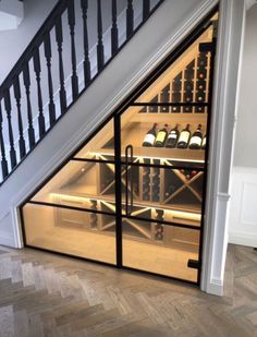 a wine cellar under the stairs in a house