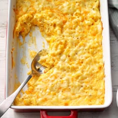 a red casserole dish filled with macaroni and cheese on a white table