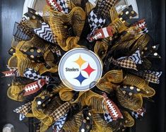 a black and gold wreath with the pittsburgh football logo on it is hanging on a door