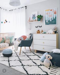 a baby's room with white walls and rugs