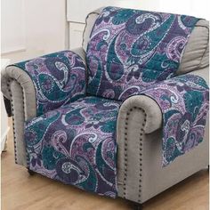 a blue and purple paisley print reclining chair in a living room with wooden floors