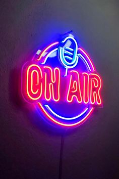 a neon sign that says oh air on the side of a wall with a microphone