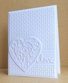 a white card with a heart and the word love on it's front side