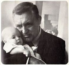 a black and white photo of a man holding a baby