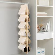 there is a shelf with shoes on it in the corner next to a white bookcase