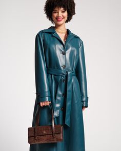 The timeless allure of a classic trench meets a modern twist. Introducing the Chelsea Coat, our first-ever faux leather trench debuting in a stunning teal hue. Elevate your outerwear style with this breathable layer as you kick off this fall in joy-sparking style. Supple lightweight faux leather trench coat Single-breasted closure, detailed with 5 tortoiseshell buttons down front center Soft pointed collard neckline Features adjustable fit with waist belt and button cuffs Styled with 2 front poc Faux Leather Trench Coat, Frances Valentine, Leather Trench, Leather Trench Coat, Handbag Shoes, Sweater Coats, Teal Blue, Waist Belt, Trench Coat