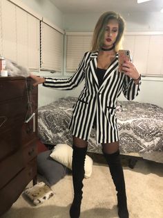 a woman is taking a selfie in her bedroom while wearing black and white striped clothes