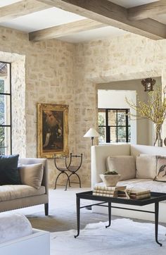 a living room filled with furniture and a painting on the wall next to a window