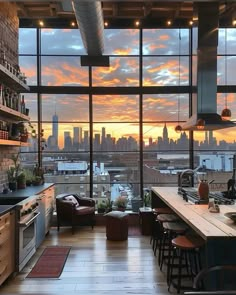 an open kitchen and living room with a view of the city at sunset or dawn