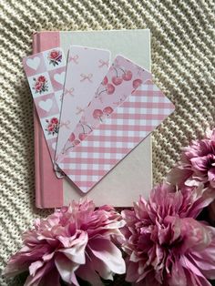 some pink flowers and cards on a table