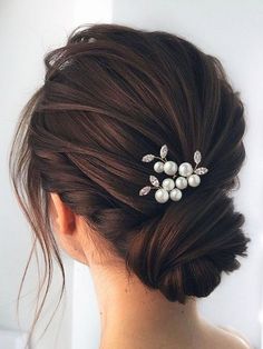 a woman wearing a hair comb with pearls on it