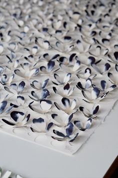 white and black flowers are arranged on a table