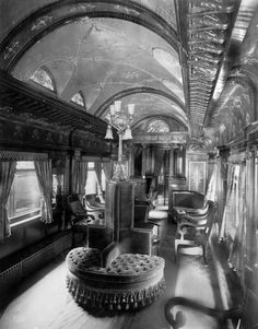 the interior of a train car with many chairs and tables on each side of it