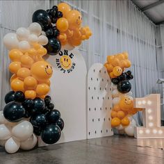 balloons are arranged in the shape of smiley faces and letters on display at an event