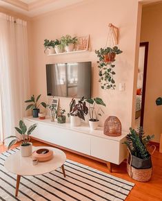 a living room with plants on the wall and a flat screen tv mounted above it