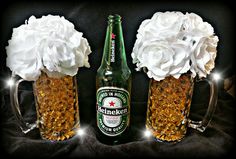 two beer bottles with flowers in them sitting next to each other on a black background