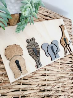 three wooden cutouts of different animals on a wicker basket