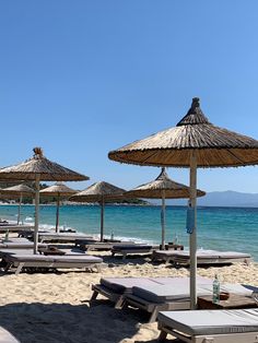 many umbrellas and lounge chairs on the beach