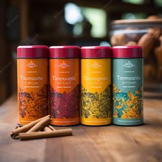 three tea tins sitting on top of a wooden table next to cinnamon sticks and spices