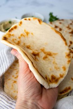 a person holding up some tortillas in their hand