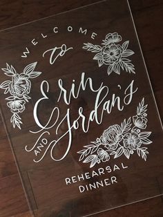 the welcome sign for an event with flowers on it is etched in clear acrylic