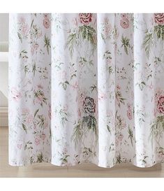 a white shower curtain with pink flowers on it