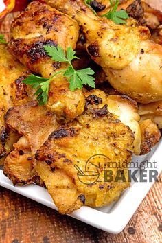 chicken wings with parsley on top served on a white plate