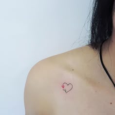 a woman with a small heart tattoo on her shoulder