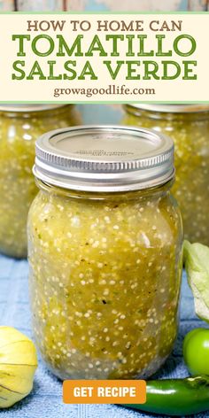 two jars filled with salsa and green peppers on top of a blue towel next to garlic