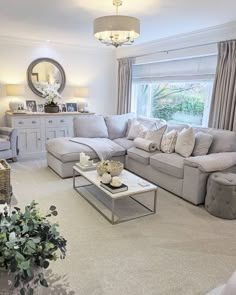 a living room filled with furniture and a large mirror on the wall above it's windows