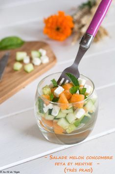 a salad with cucumbers, carrots and mint in a small glass bowl