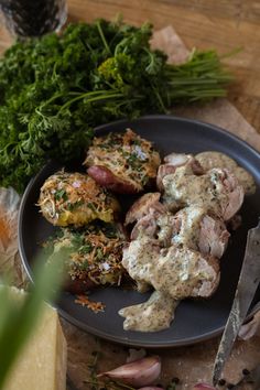 pork tenderion in creamy german mustard dill sauce and smashed garlic potatoes on a black plate