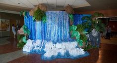 a waterfall made out of ice and snow in a lobby with decorations on the walls